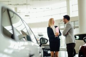 Salesperson selling cars at dealership